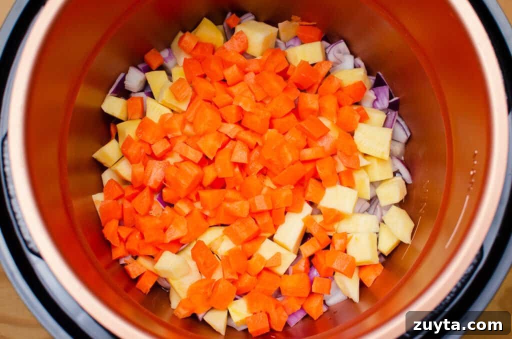 Hearty Quinoa and Vegetable Stew Recipe 9 Chopped Carrot, Swede and red onion frying in olive oil in a pressure cooker pot