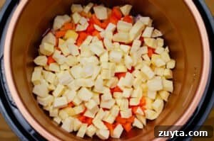 Hearty Quinoa and Vegetable Stew Recipe 3 Chopped Parsnip, Carrot, Swede and red onion frying in olive oil in a pressure cooker pot