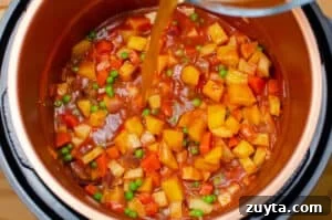 Hearty Quinoa and Vegetable Stew Recipe 5 Tomato passata being poured into the pan with vegetables