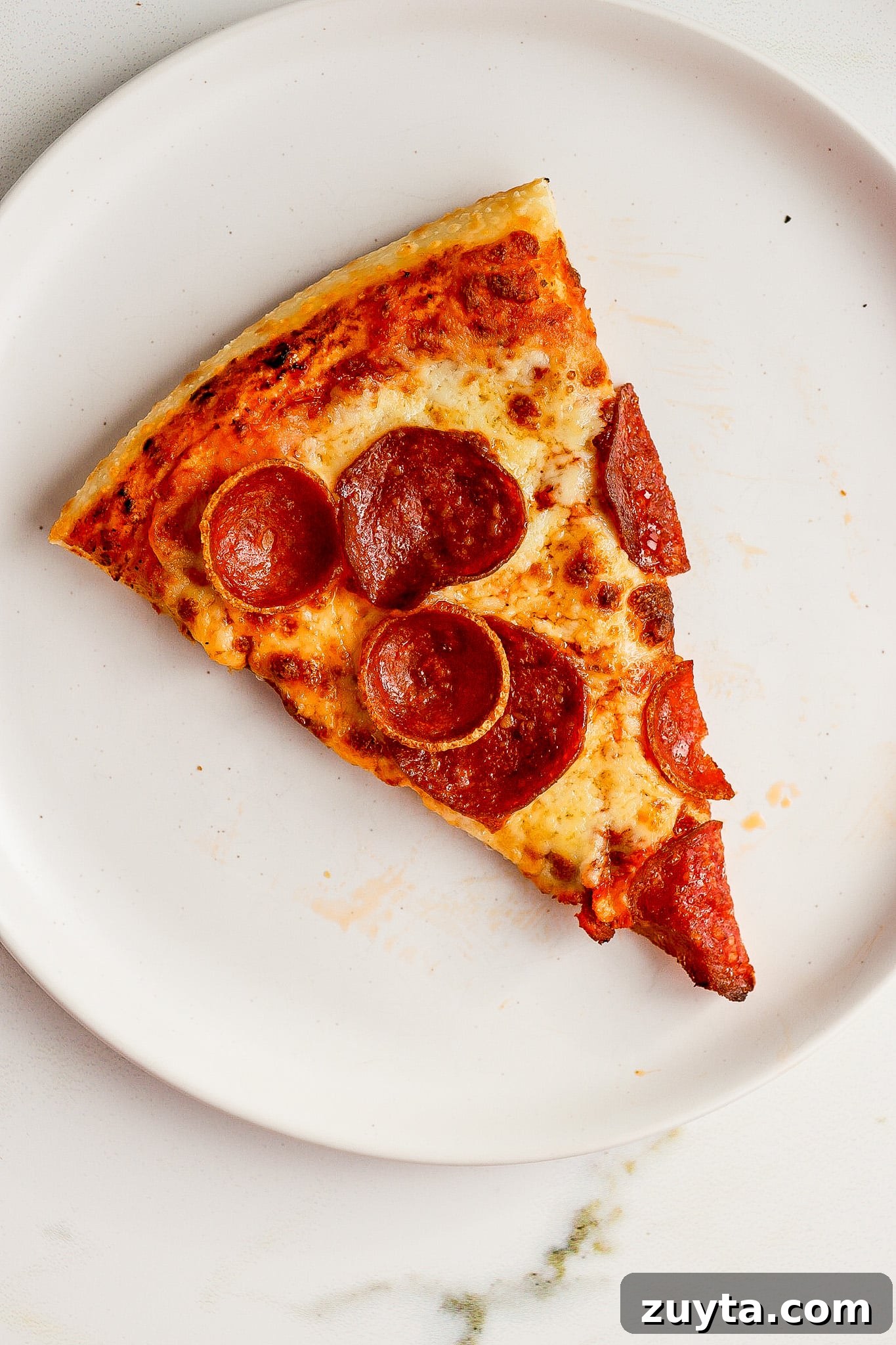 top down view of pepperoni pizza on white plate