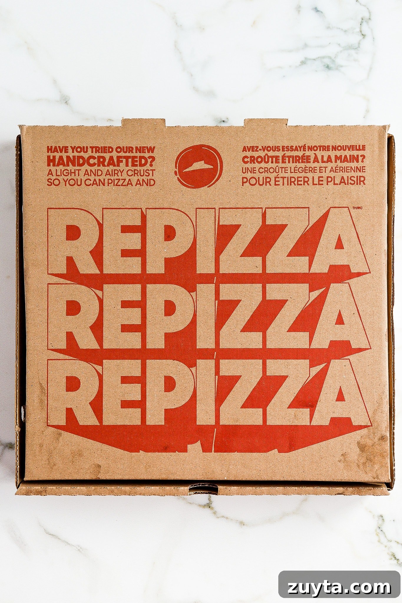 top down view of pizza box on marble background