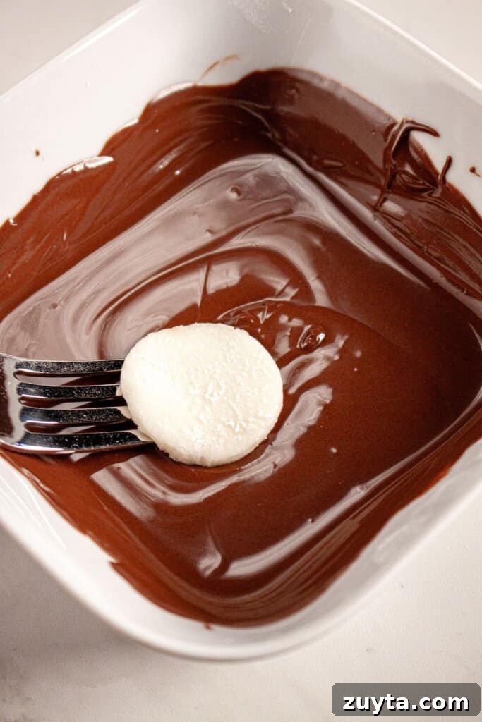 Filling being dipped in chocolate with a fork.