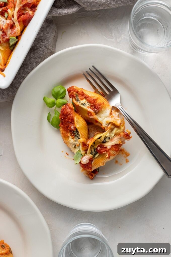 Creamy Spinach and Ricotta Stuffed Shells Recipe 7 Small white plates with individual servings of spinach and ricotta stuffed shells.