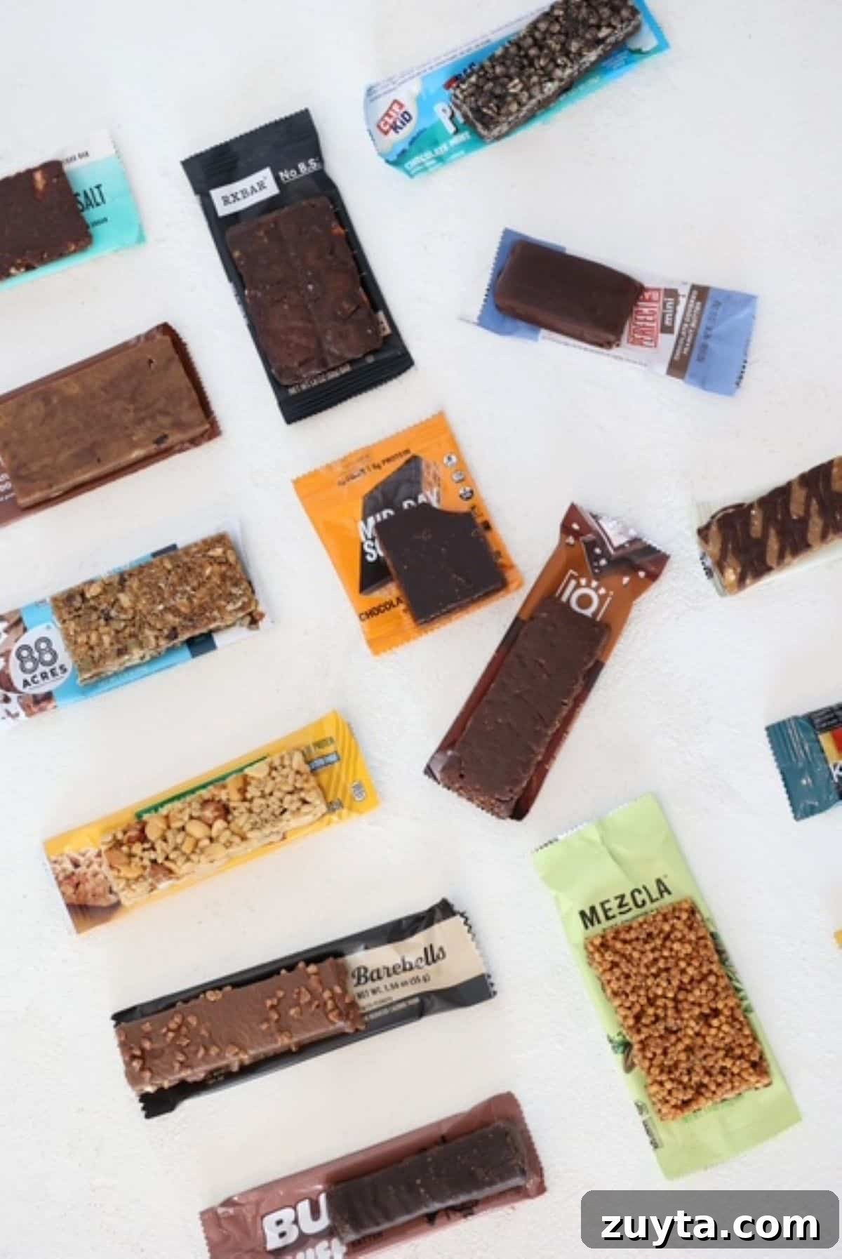 RD-Approved Protein Bars for Adults and Kids 3 Several different protein bars placed on top of their wrappers.