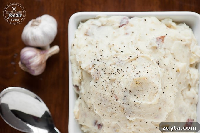 Creamy Roasted Garlic Mashed Potatoes Recipe 4 mashed potatoes in square dish with garlic on side