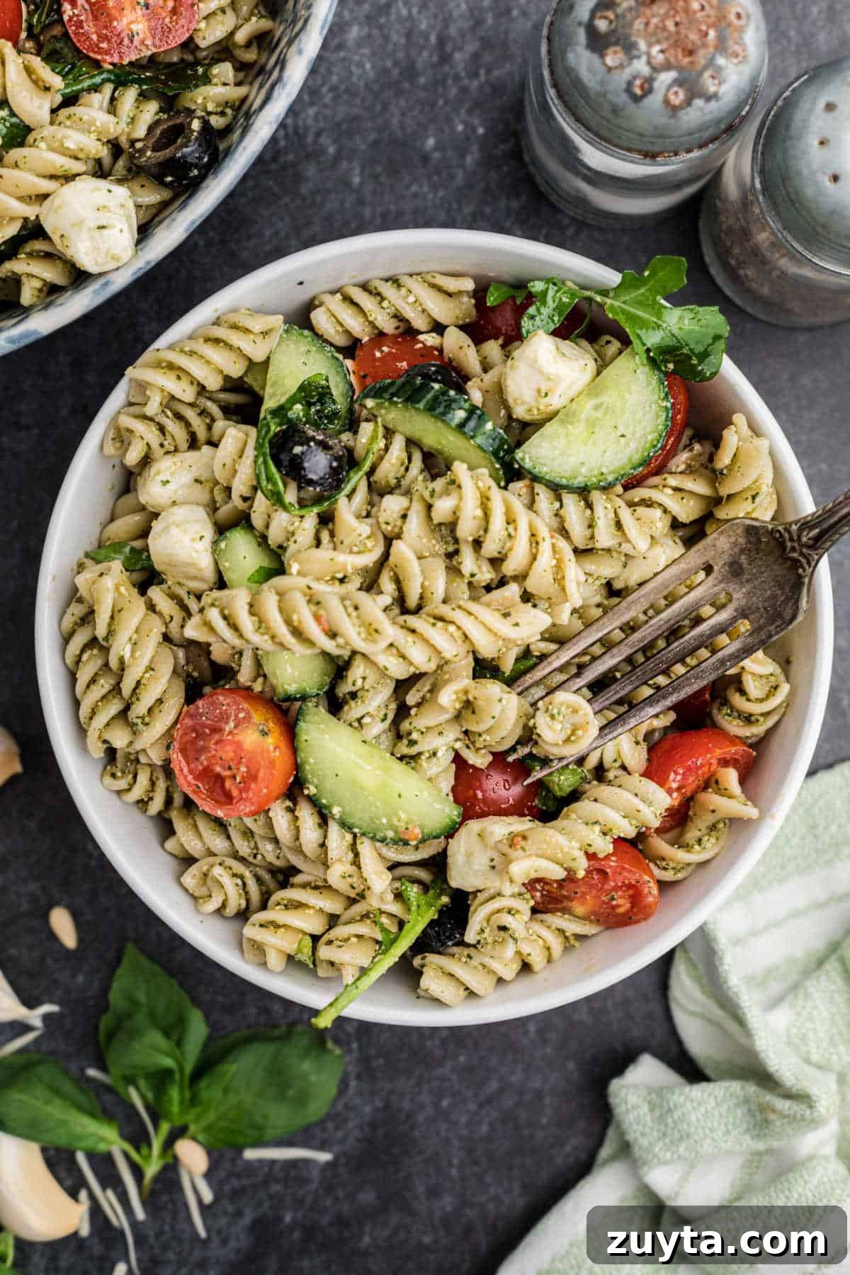 Summer Pesto Pasta Salad with Cherry Tomatoes and Mozzarella 11 A dished up bowl of summer pesto pasta salad with a fork digging in.