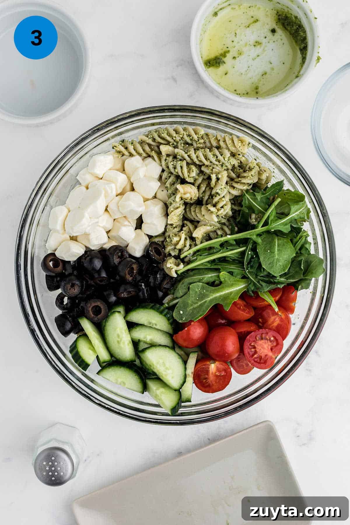 Summer Pesto Pasta Salad with Cherry Tomatoes and Mozzarella 5 Close up overhead shot of a bowl of ingredients to make a pesto pasta salad.