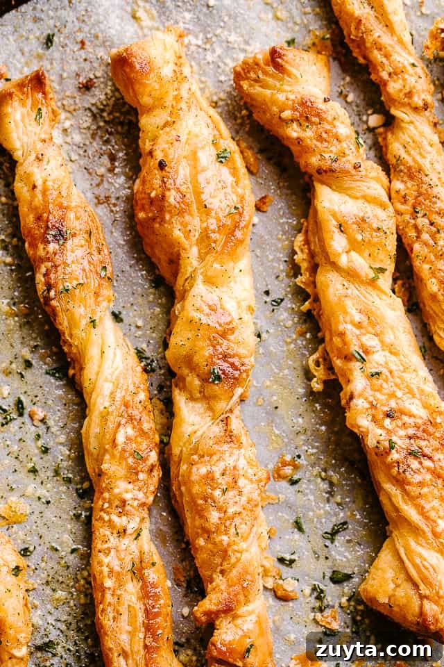 These cheese sticks are addictive movie snacks and great party food ideas! Crunchy puff pastry, melty cheesy and your favorite spices - YUM! Puff pastry cheese sticks fresh out of the oven on their baking sheet.