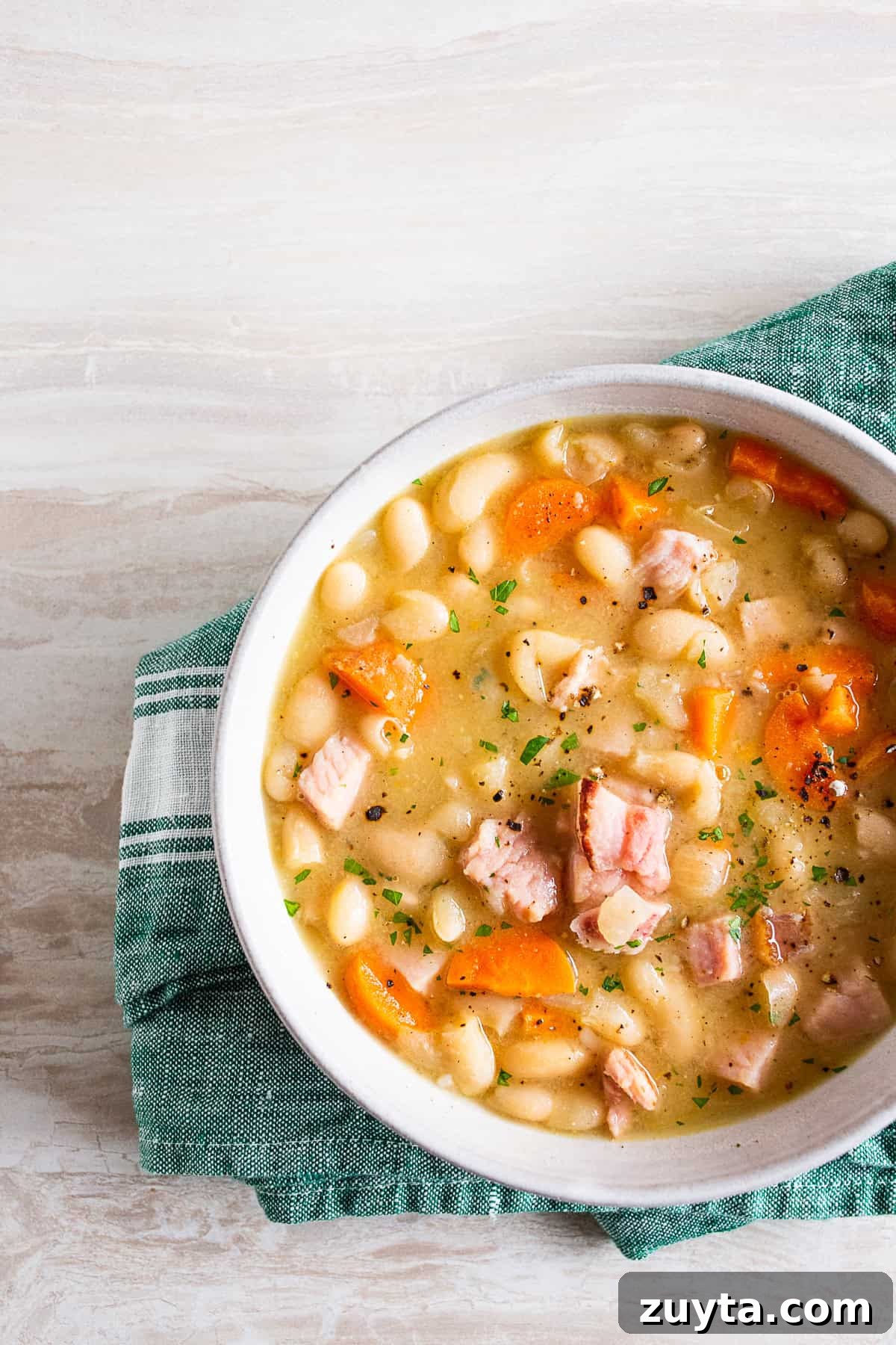 Hearty Ham and Bean Soup Recipe 3 easy ham and bean soup in a ceramic bowl.