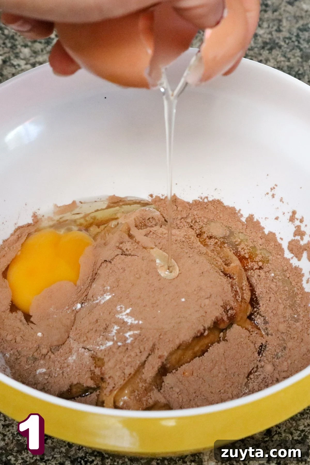 Flourless Peanut Butter and Jam Cookies (Dairy-Free Recipe) 4 Egg being cracked into a bowl with cacao powder and peanut butter.