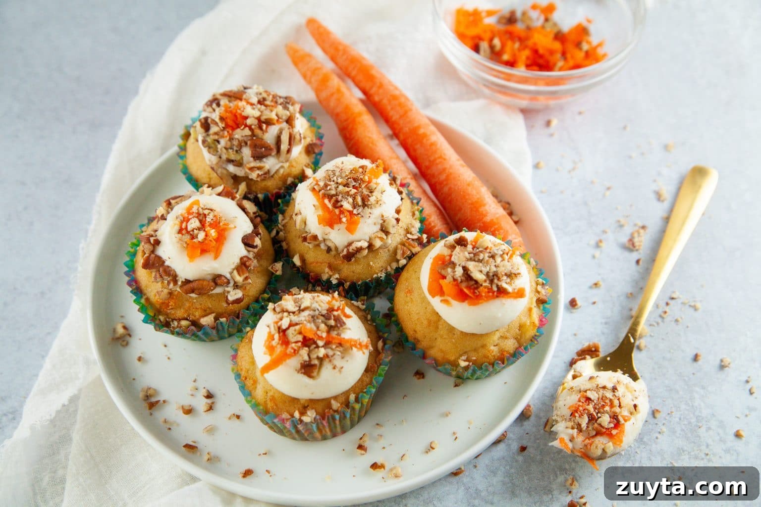 Carrot Cake Cupcakes Recipe with Cream Cheese Frosting 2 carrot cupcakes on a platter.