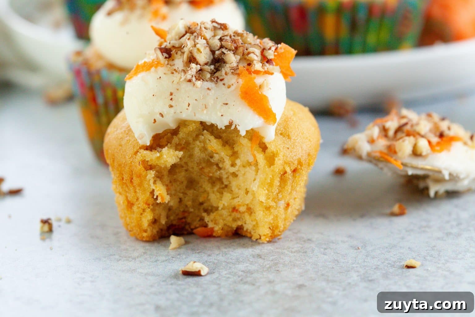 Carrot Cake Cupcakes Recipe with Cream Cheese Frosting 6 a single cupcake with a bite out of it.