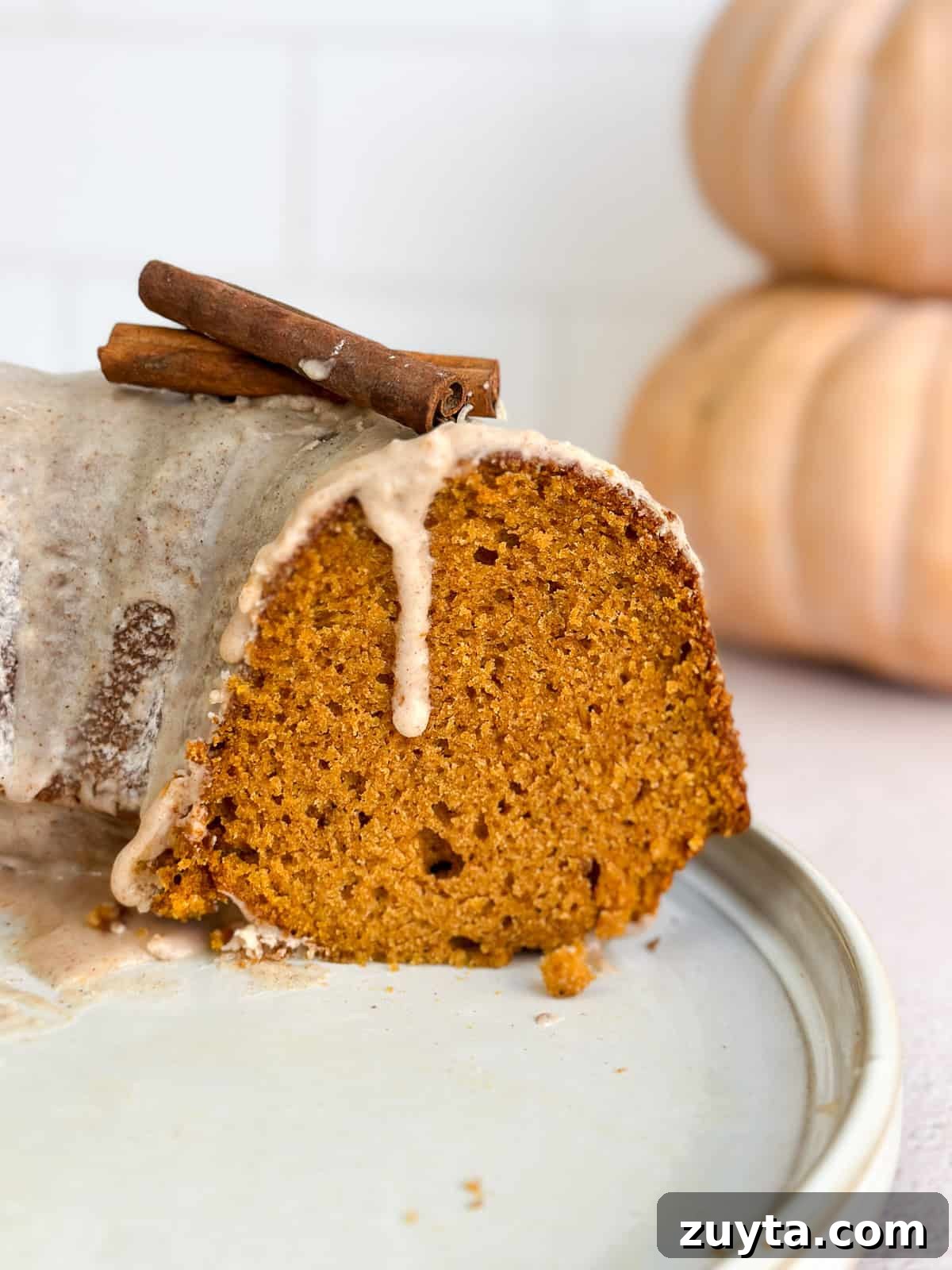 Moist Pumpkin Bundt Cake Recipe with Cinnamon Glaze 2 a side view of the cut pumpkin bundt cake to see inside.