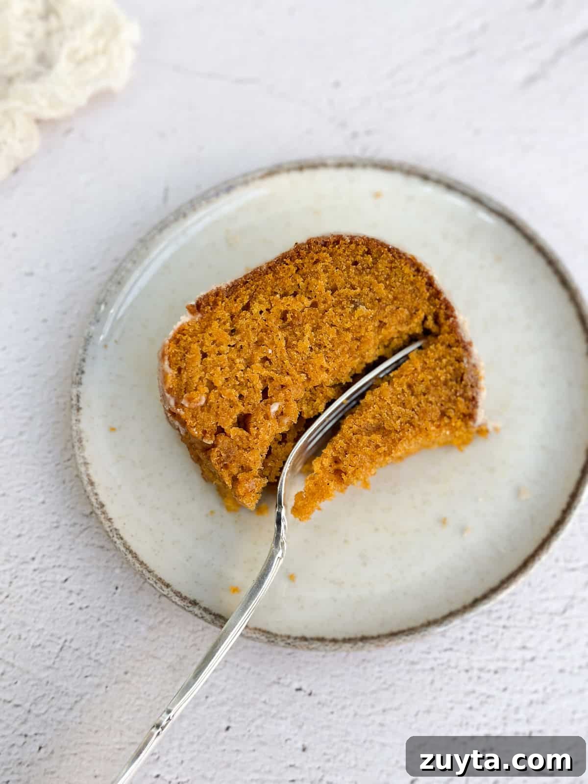 Moist Pumpkin Bundt Cake Recipe with Cinnamon Glaze 3 a fork cutting into a slice of cake.