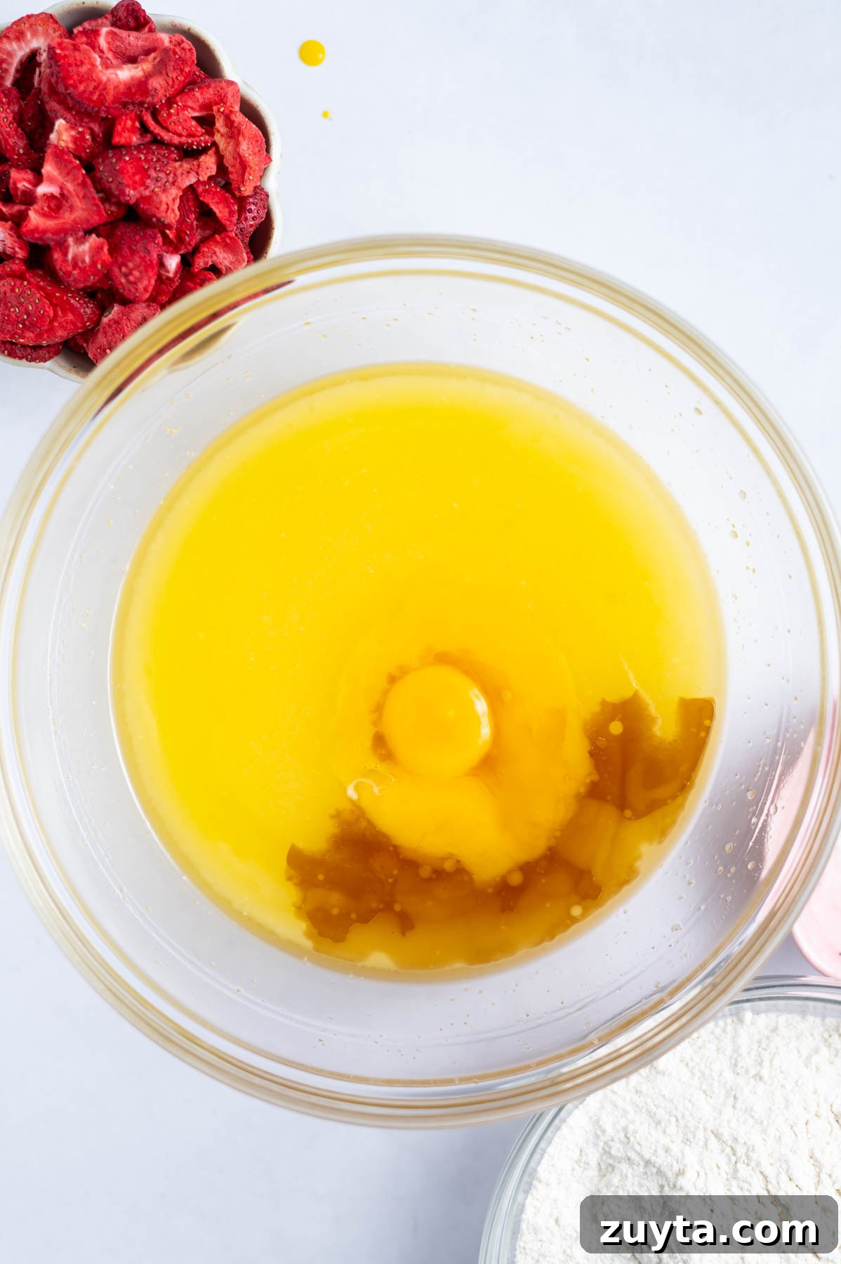 egg yolk and vanilla added to melted butter and sugar in a bowl
