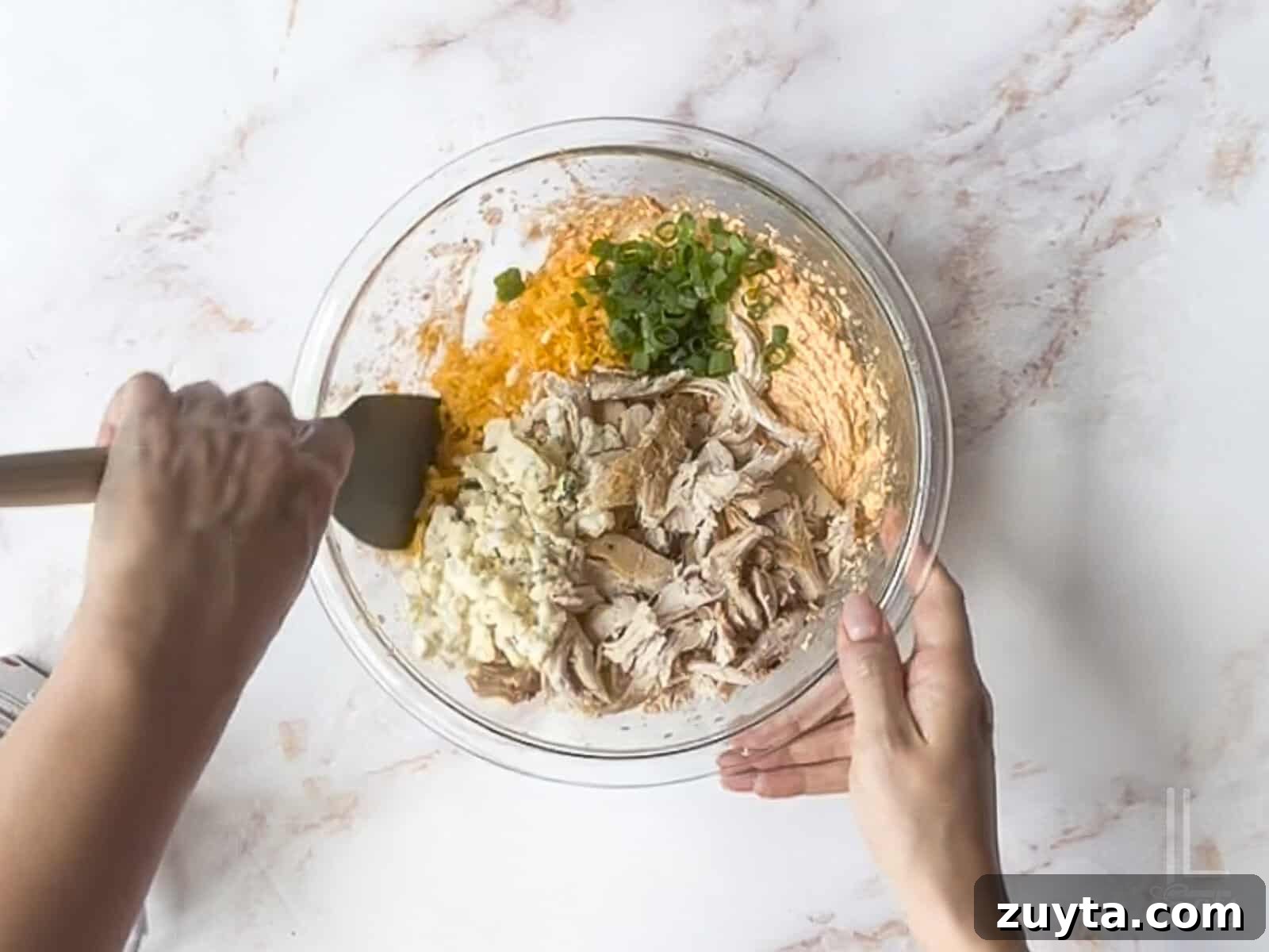 Buffalo Chicken Pinwheels Appetizer Recipe 6 hand-stirring chicken, blue cheese, cheddar cheese, and green onions into cream cheese mixture.