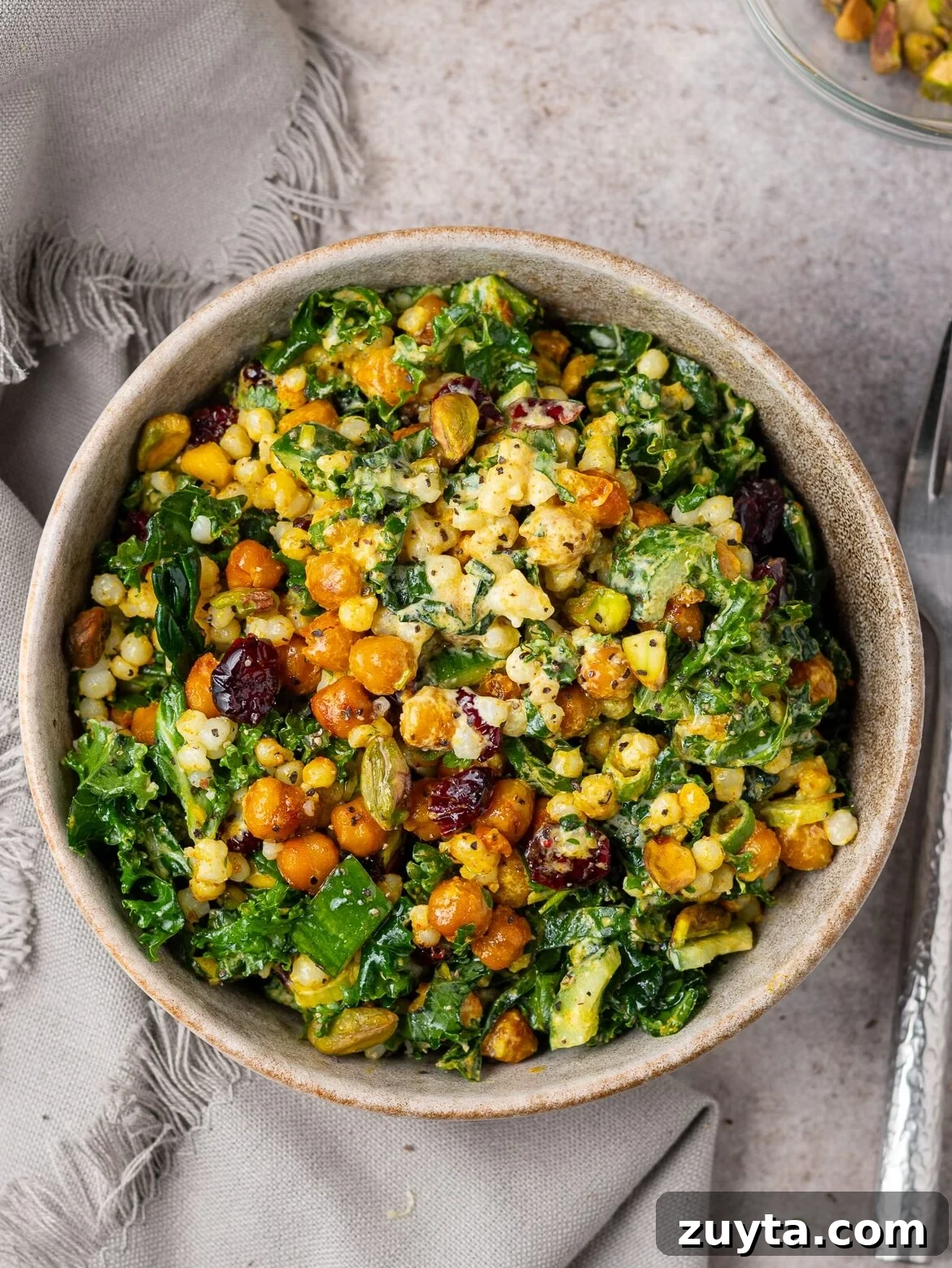 dressed and tossed kale and couscous salad in a bowl