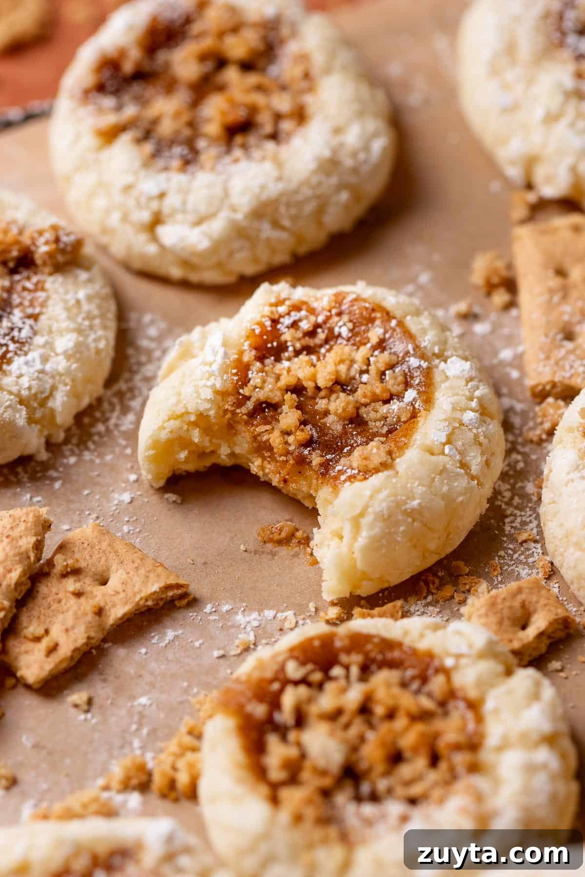 Pumpkin Cheesecake Cookies Recipe 2 Pumpkin cream cheese cookie with a bite missing.