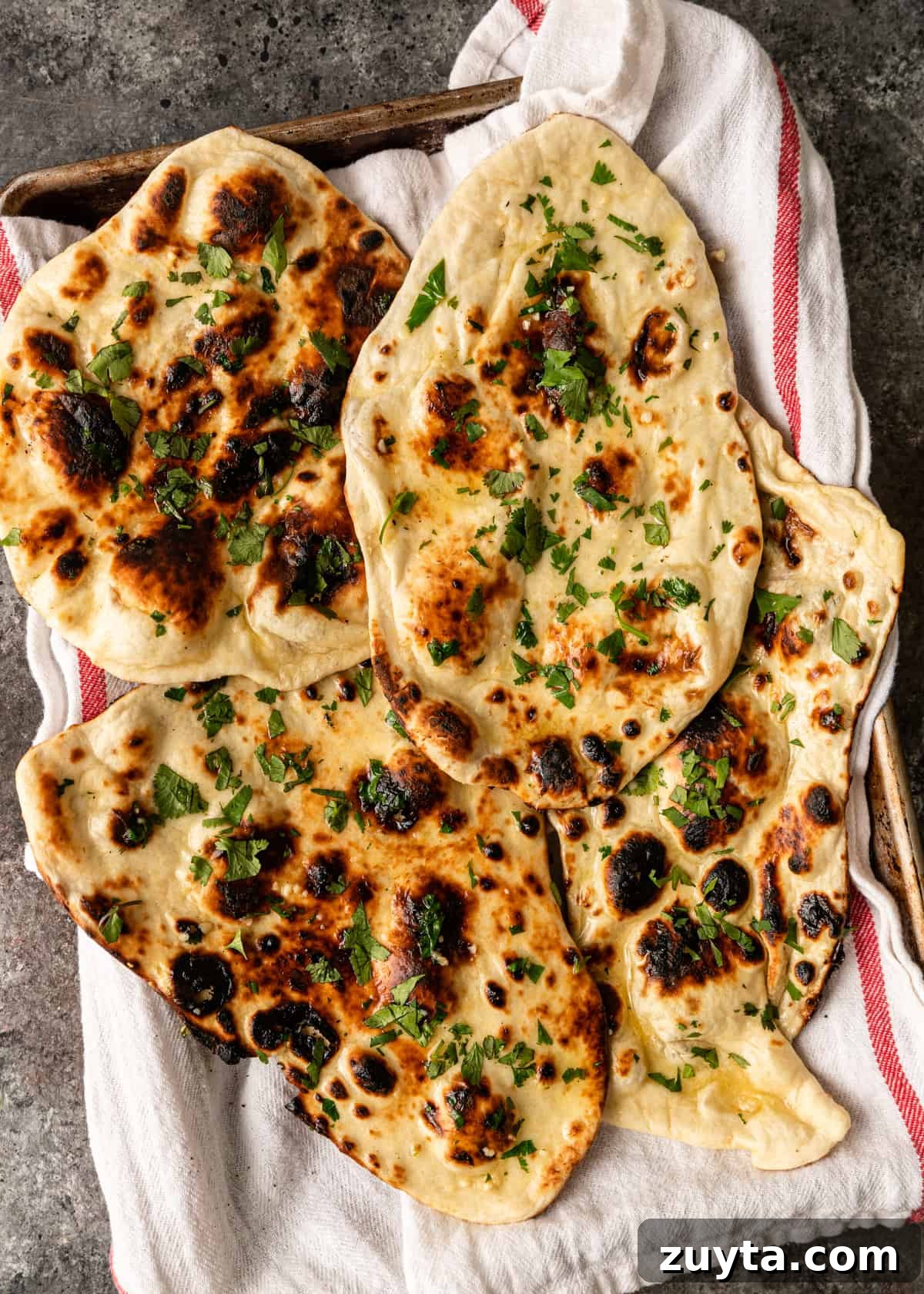 How to Make Naan at Home: Authentic Indian Flatbread 12 garlic naan recipe with cilantro on tray