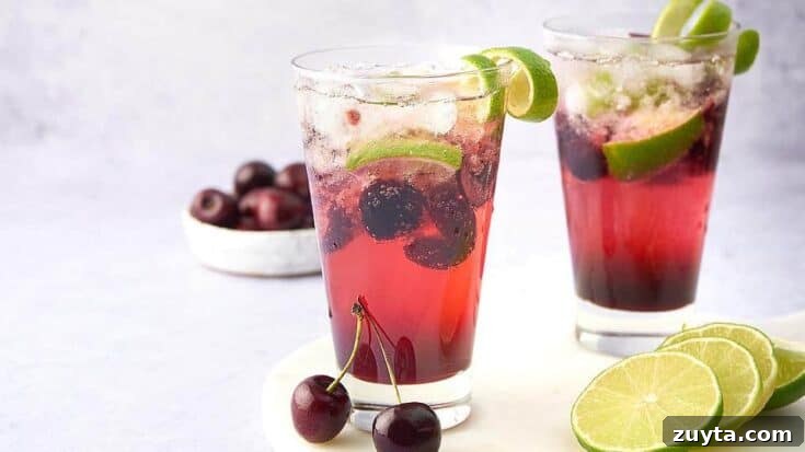 A Cherry Caipirhinia garnished with cherries and lime slices.