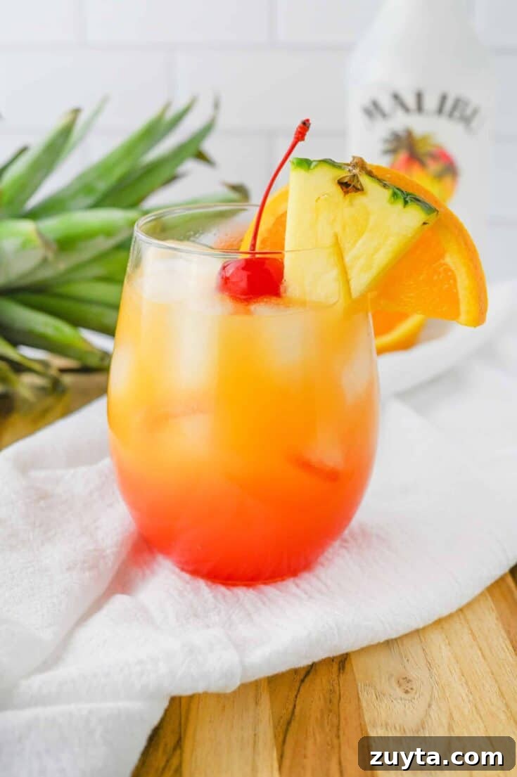 A malibu sunset cocktail with yellow, orange and red layers.