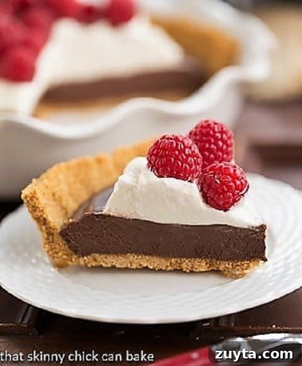 Chocolate Satin Pie - Dreamy chocolate filling in a graham cracker crust! Chocolate Satin Pie slice on a white dessert plate.