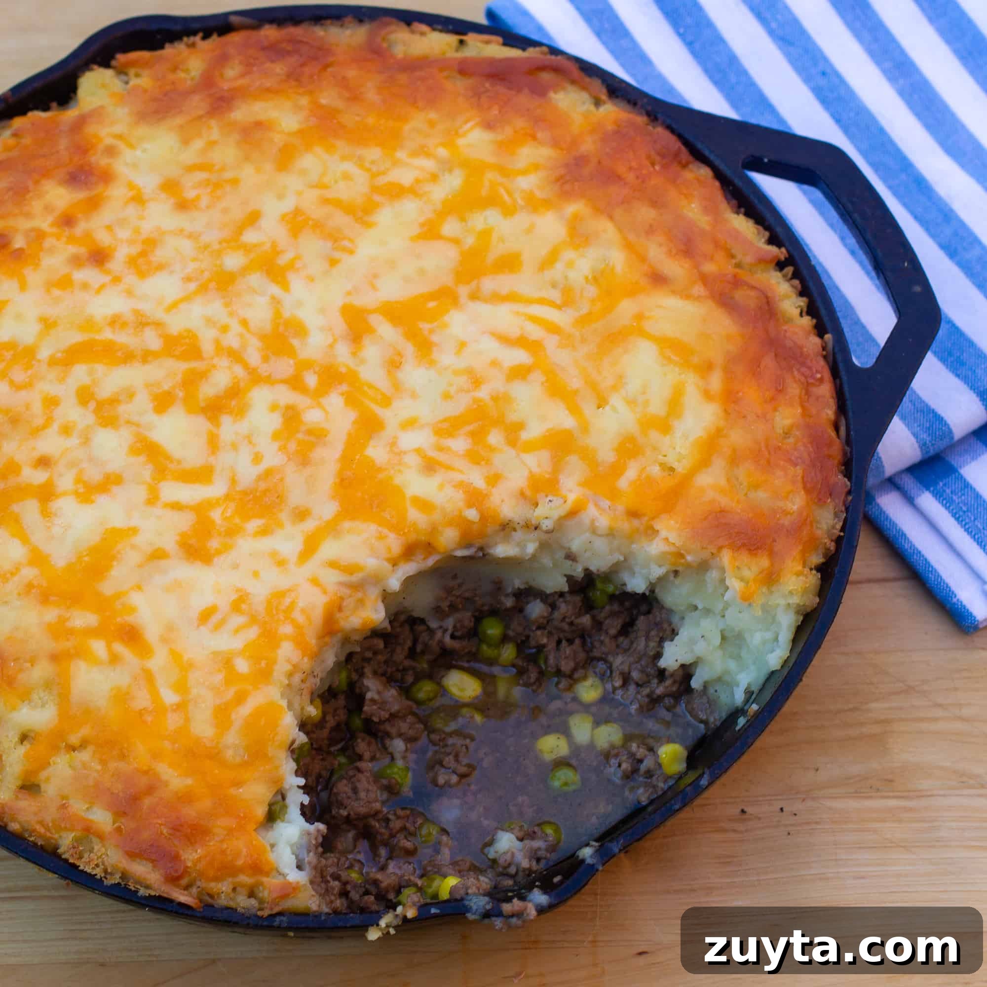 Skillet Shepherd's Pie with Cheddar Mashed Potatoes 2 How to make shepherd's pie in a cast iron skillet! Baked recipe has beef filling with peas and corn, topped with mashed potatoes and grated cheddar cheese.