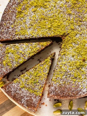 Italian Torta caprese topped with ground pistachios and powdered sugar.