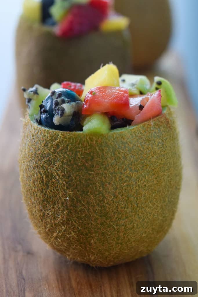 Tropical Fruit Salad in Kiwi Cups Recipe 3 Close up side view of a kiwi stuffed with tropical fruit salad