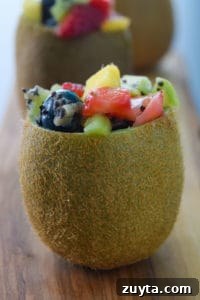 Tropical Fruit Salad in Kiwi Cups Recipe 7 Close up side view of a kiwi stuffed with tropical fruit salad