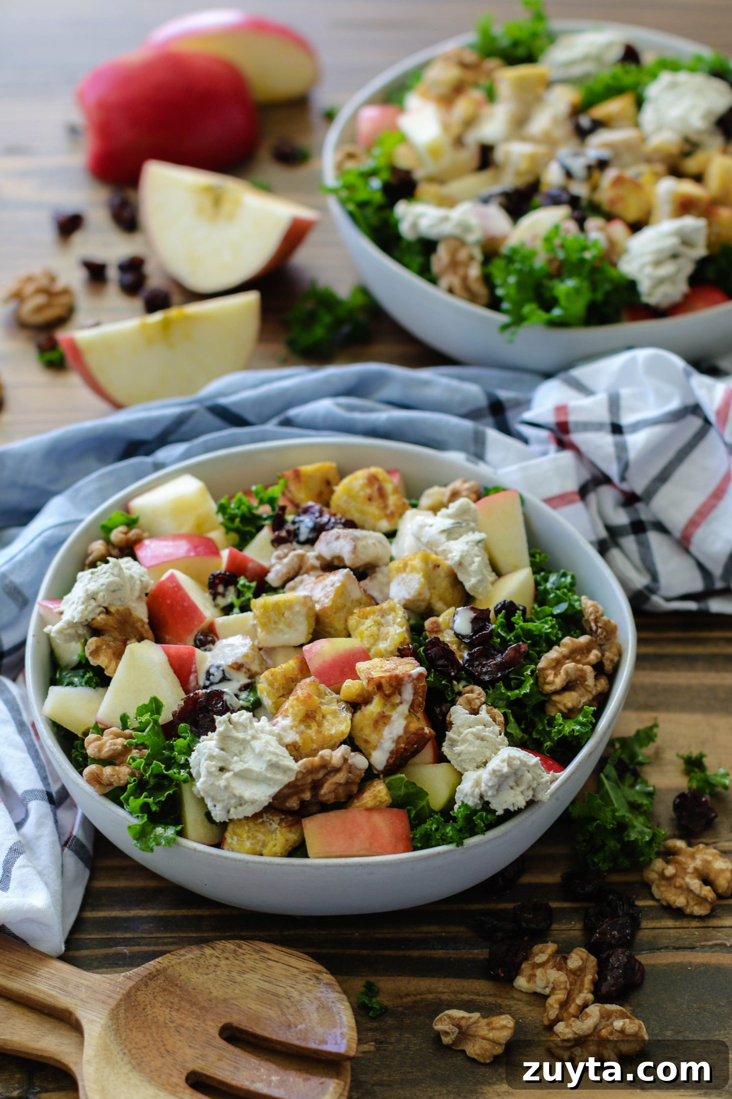 Tempeh and Kale Salad with Cranberries and Apple Recipe 4 Cran-Apple Tempeh Kale Salad served in bowls with wooden spoons and walnuts scattered by Flora & Vino