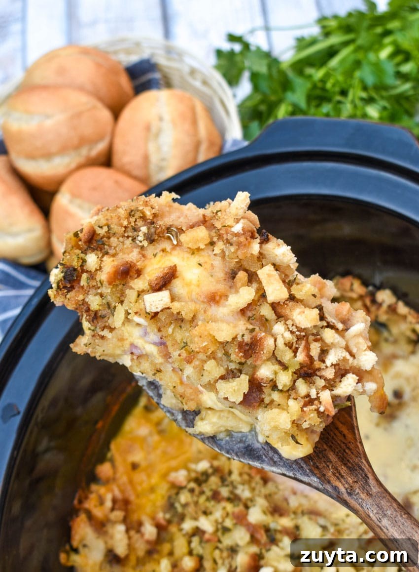 Slow Cooker Chicken Cordon Bleu Recipe with Ham and Swiss 3 a wooden spatula holding up a piece of slow cooker chicken cordon bleu