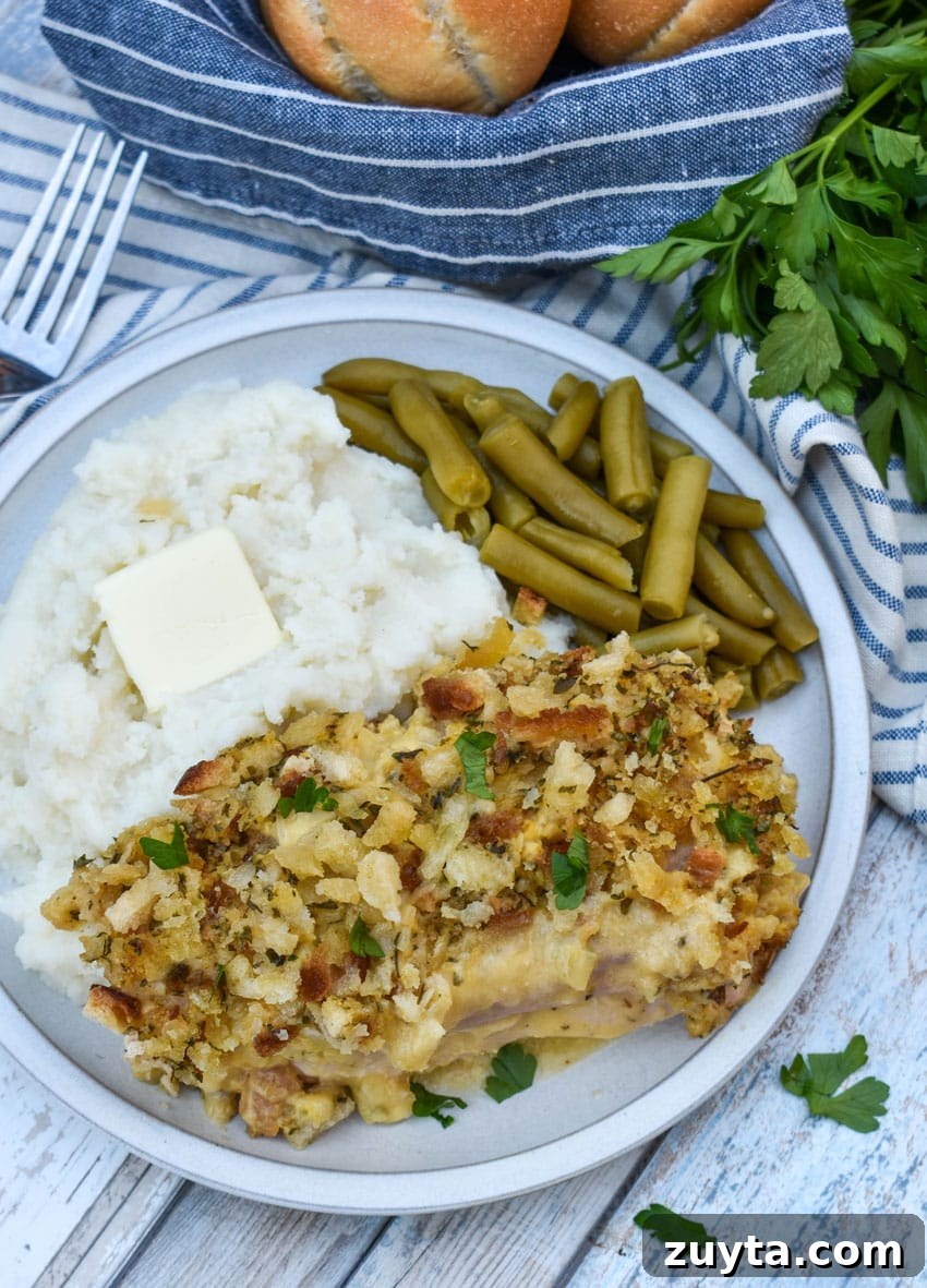 Slow Cooker Chicken Cordon Bleu Recipe with Ham and Swiss 4 slow cooker chicken cordon bleu next to mashed potatoes and canned green beans on a white plate