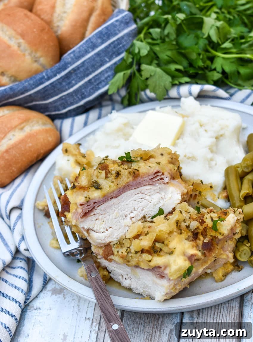 Slow Cooker Chicken Cordon Bleu Recipe with Ham and Swiss 6 slow cooker chicken cordon bleu next to mashed potatoes and canned green beans on a white plate
