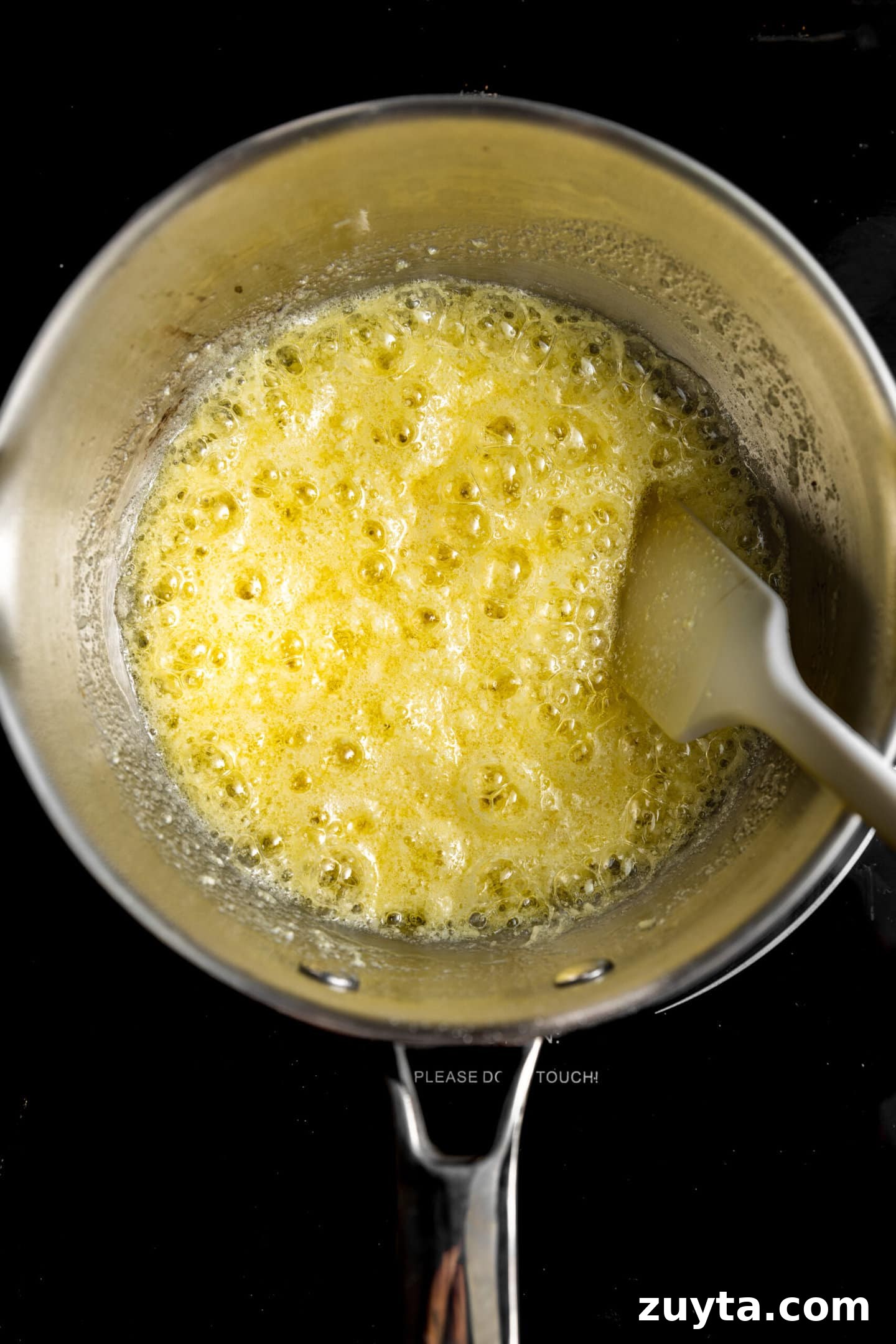 Small-Batch Brown Butter Chocolate Chip Cookie Recipe 5 Dry milk powder being stirred into melted butter over the stove