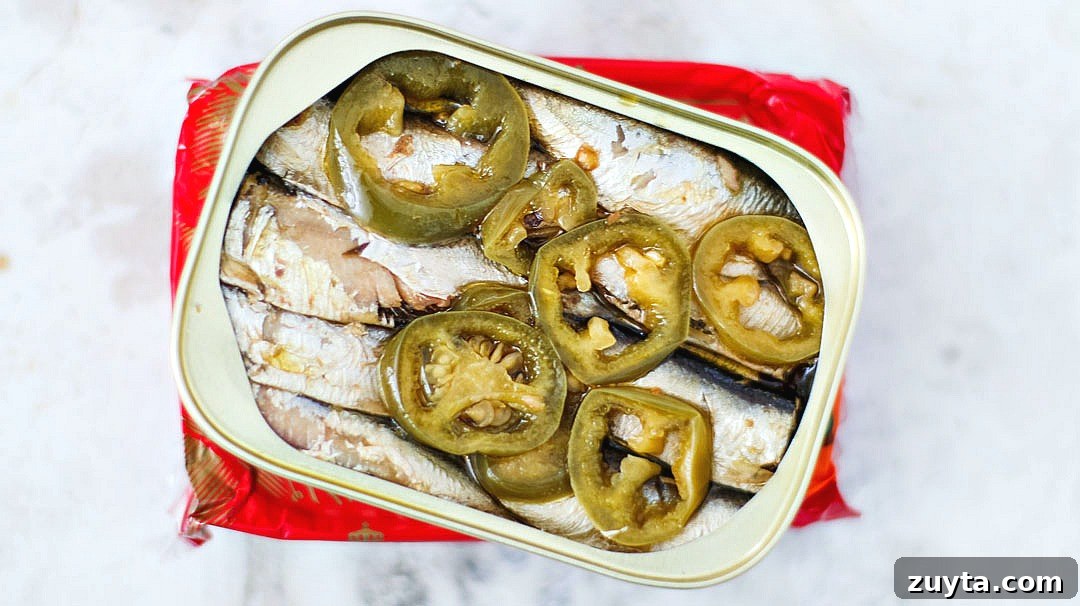 Opened can of King Oscar sardines with slices of jalapenos.