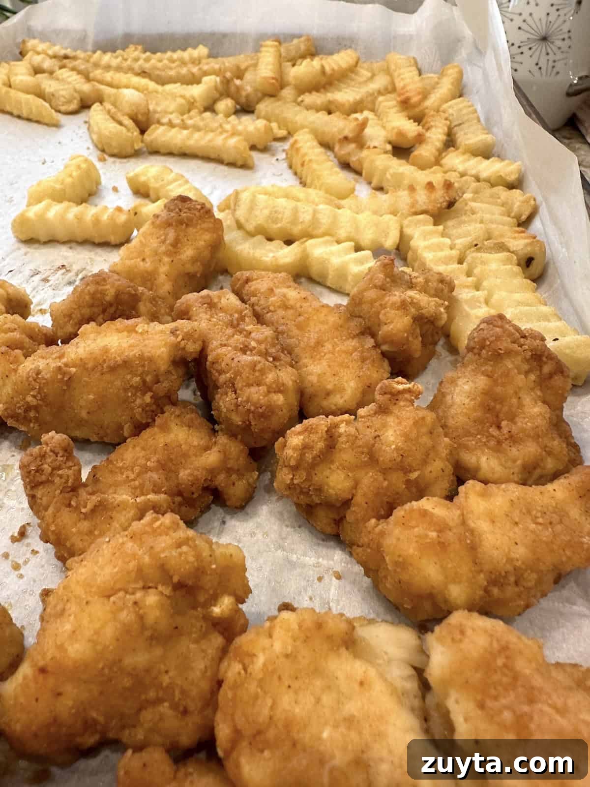 French Tacos Explained: Origins, Ingredients and Where to Try 5 French fries and chicken nuggets on a baking sheet.