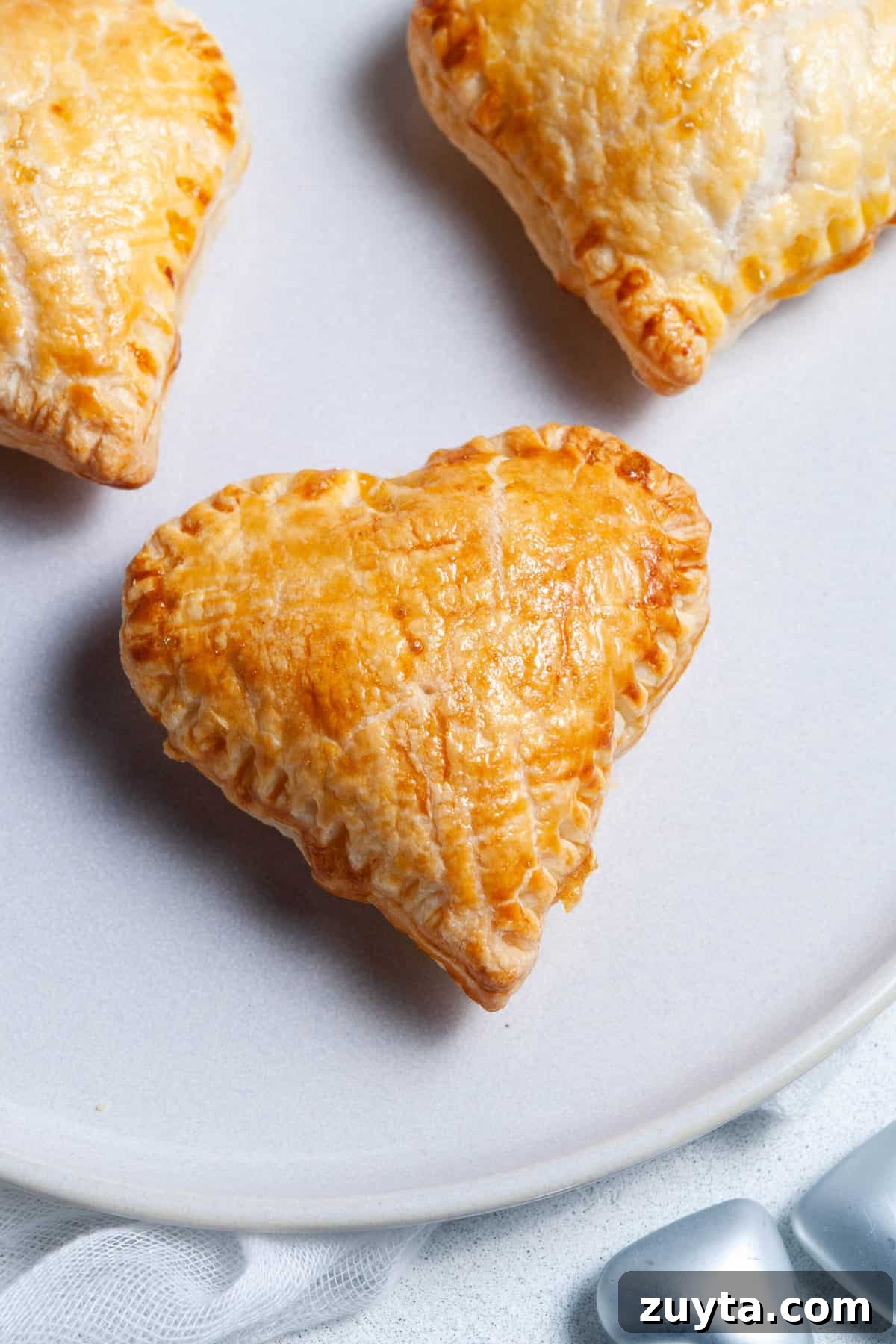 Ham and Cheese Puff Pastry Hearts Recipe 7 up close shot of three pastry hearts that have been cooked.