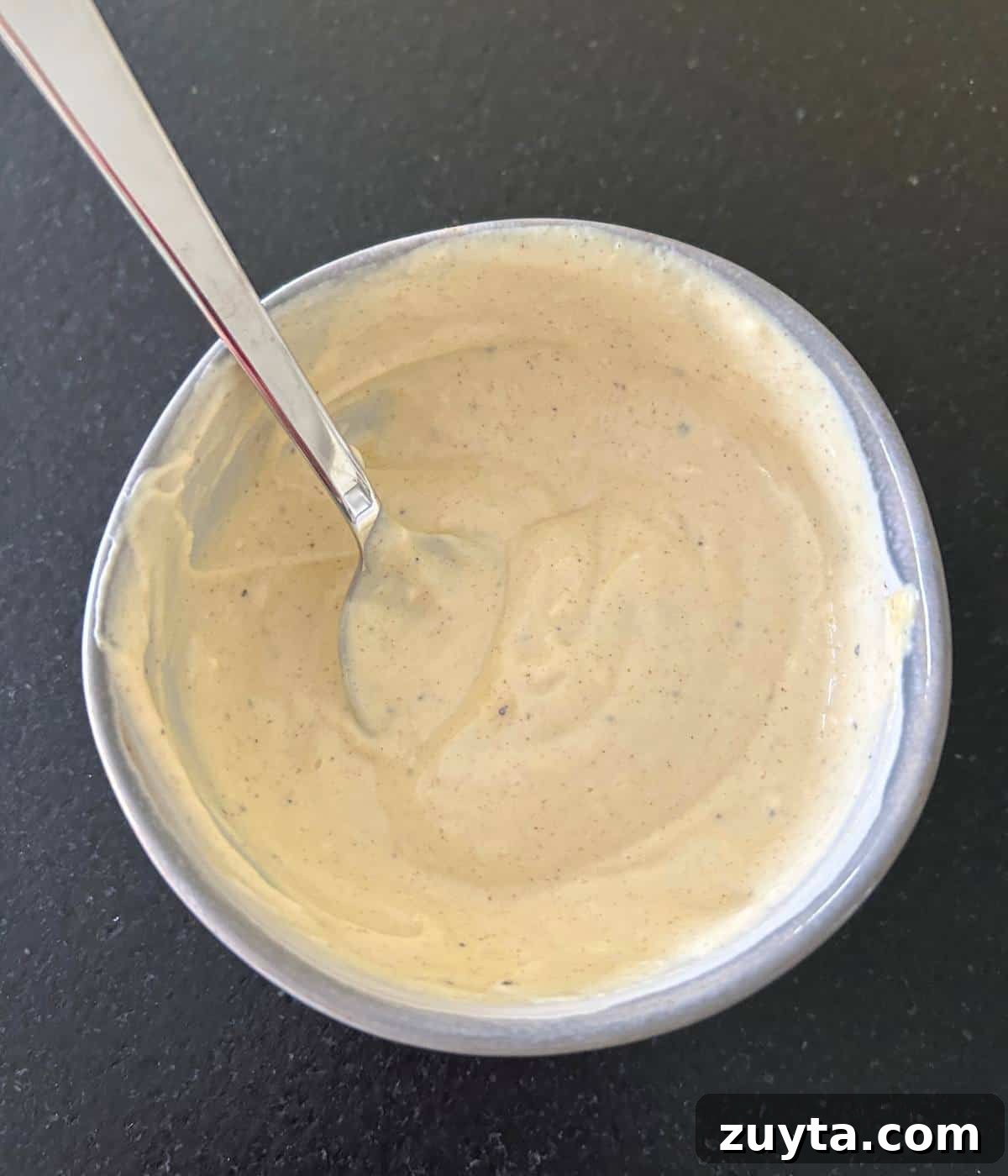 Dijon mustard and mayonnaise spread in bowl with spoon.