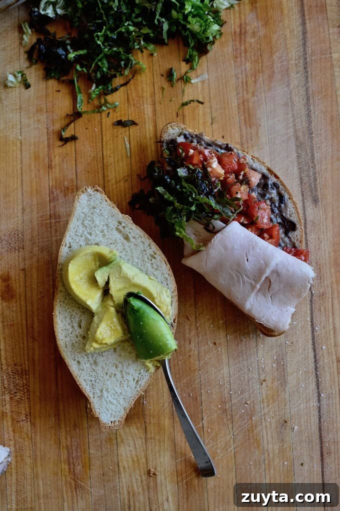 Cold Mexican Turkey Torta with thinly sliced roast turkey, avocado, and oregano-marinated tomatoes