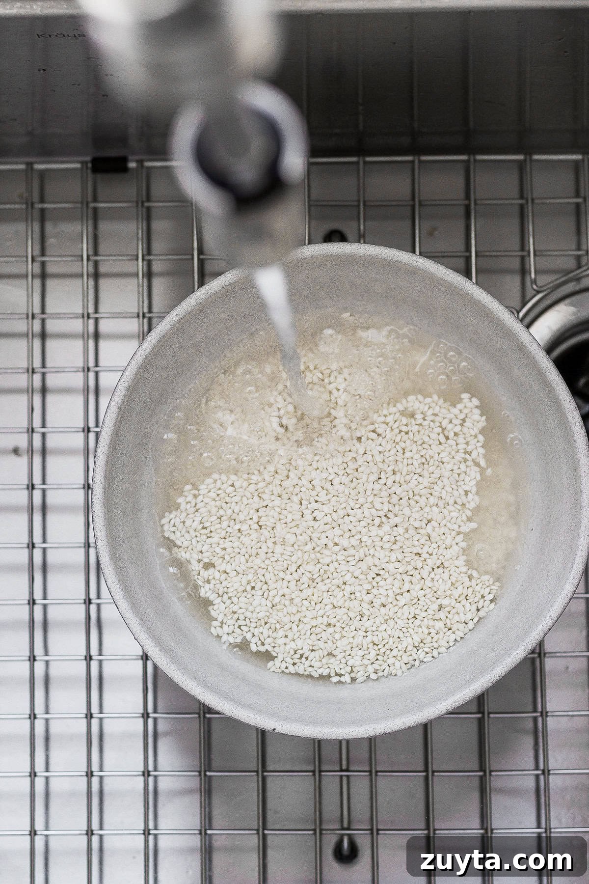 Rinsing sticky rice in a bowl rinsing sticky rice in a bowl in the sink