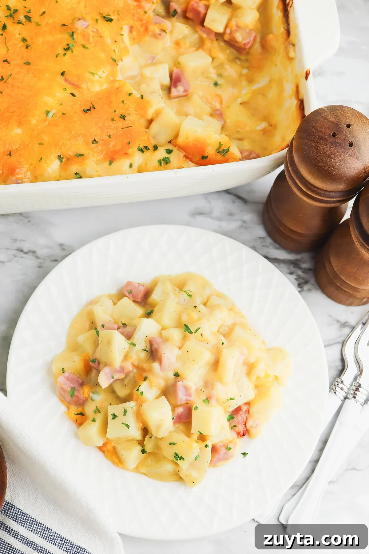 Creamy Cheesy Ham and Potato Casserole 2 Ham and potato casserole served on a white plate.