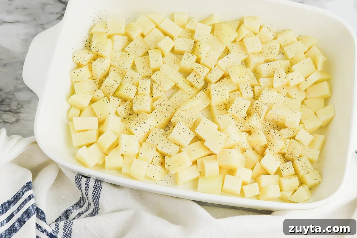 Creamy Cheesy Ham and Potato Casserole 4 Diced potatoes in a casserole dish.