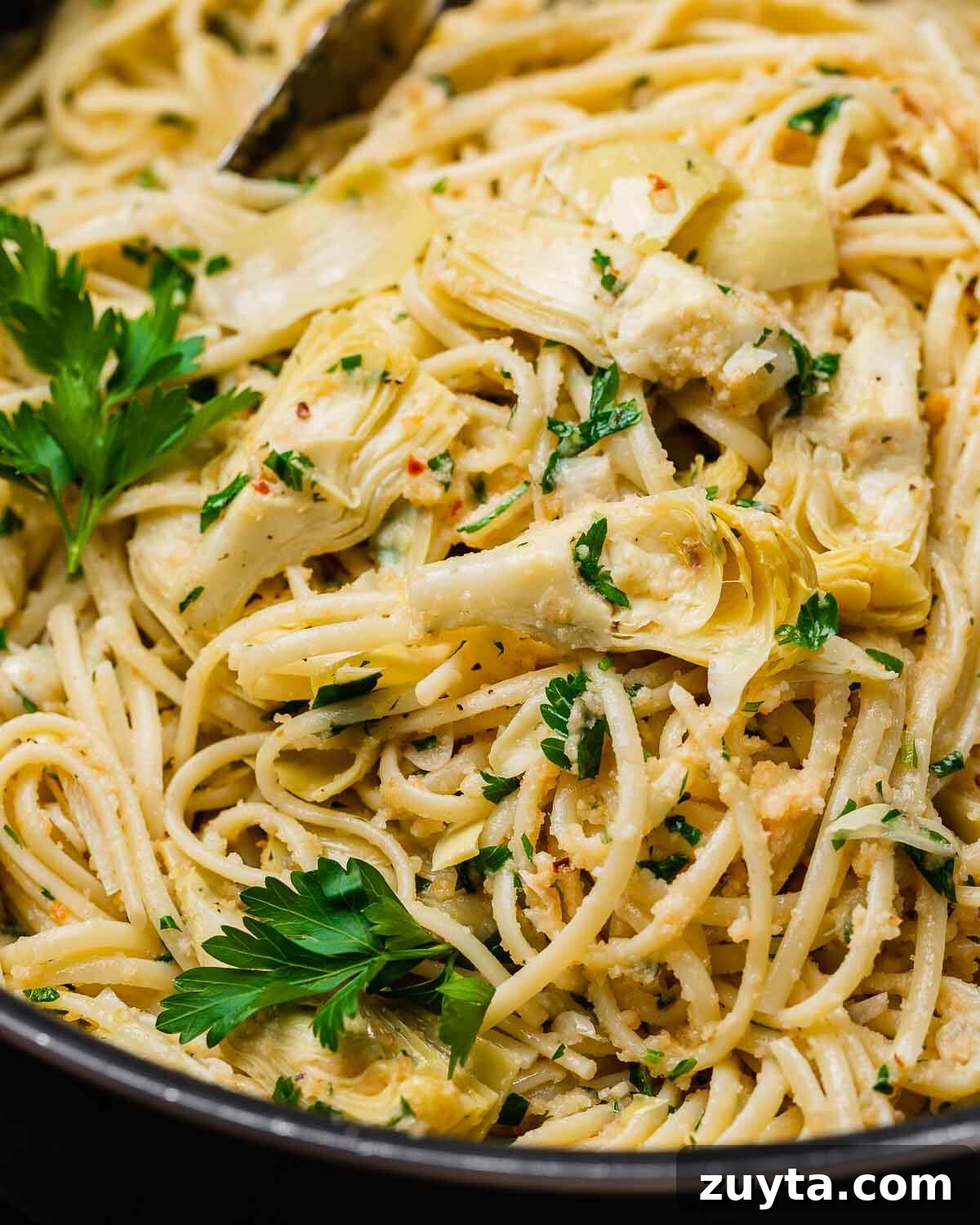 Artichoke Pasta with Crispy Breadcrumbs 5 Closeup of pasta with artichoke hearts and breadcrumbs in a pan.
