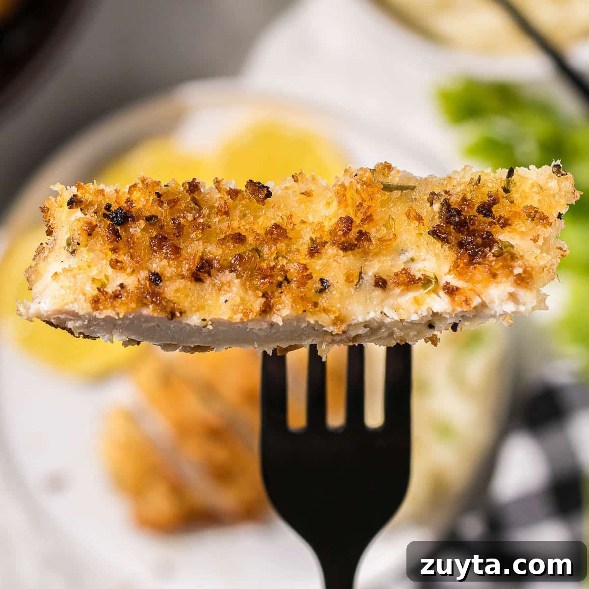 Crispy Italian Chicken Cutlets Recipe 9 A piece of breaded chicken on a fork.