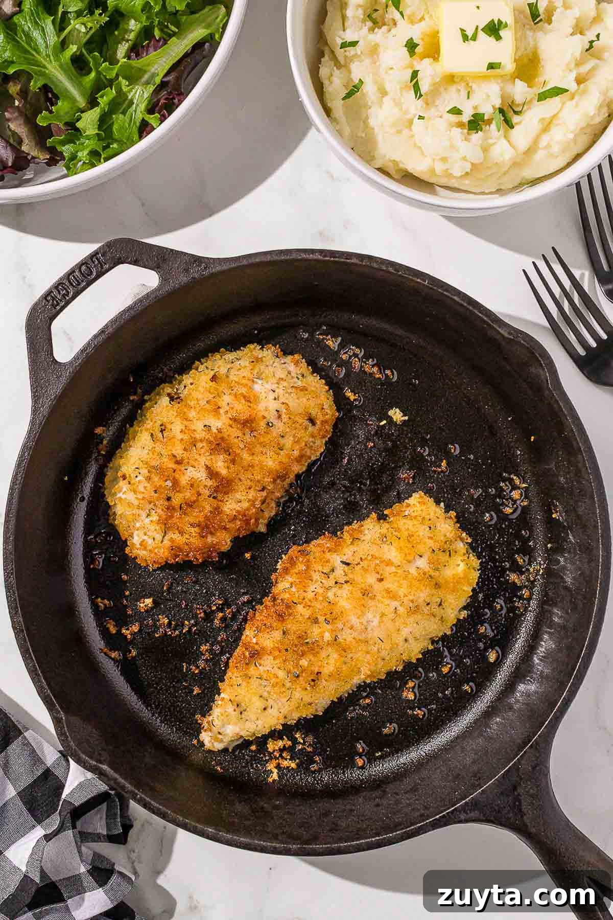 Crispy Italian Chicken Cutlets Recipe 10 A cast iron skillet with Italian chicken cutlets.
