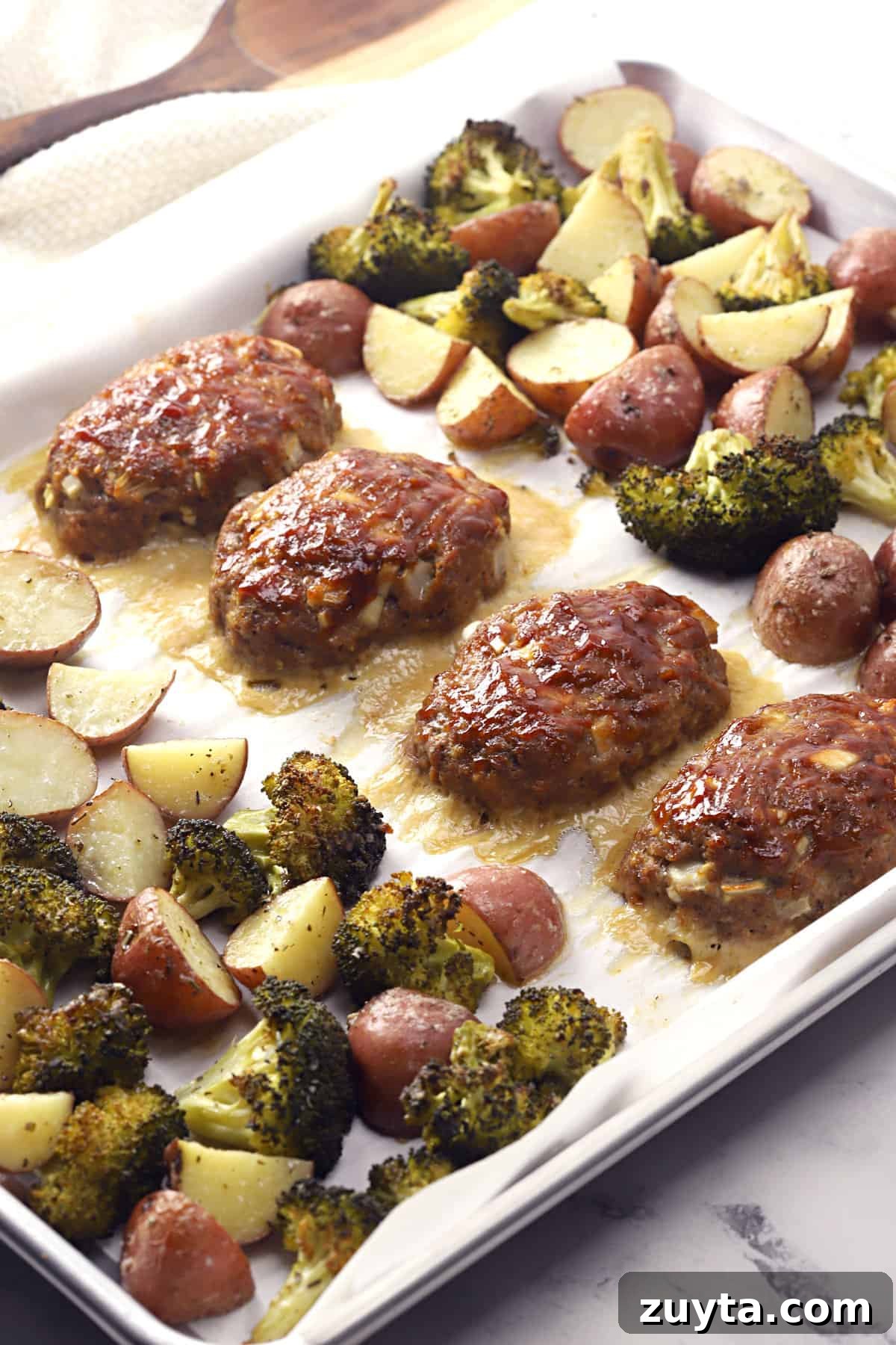 Sheet Pan Dinner Recipes for Quick Weeknight Meals 14 Meat loaves with vegetables on a pan.