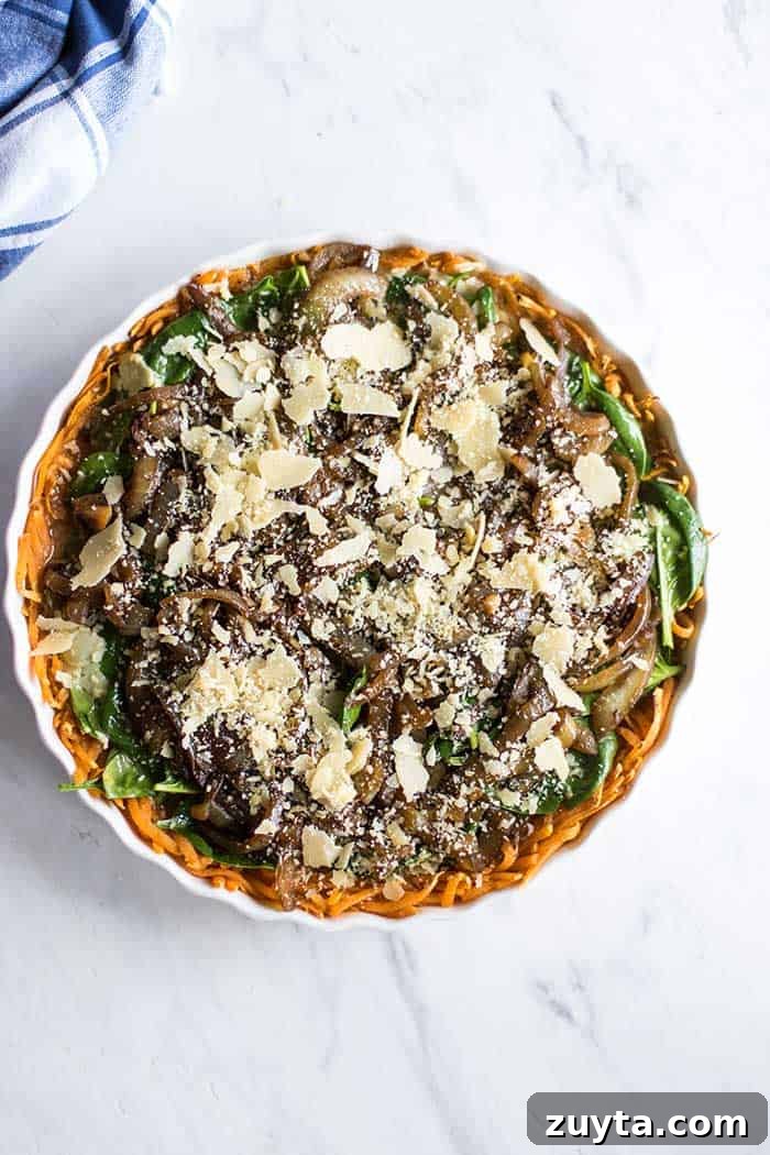 Sweet Potato and Spinach Frittata Recipe with Caramelized Onions 5 A baking dish with layers of sweet potato, eggs, spinach, and caramelized onions, ready to be baked.