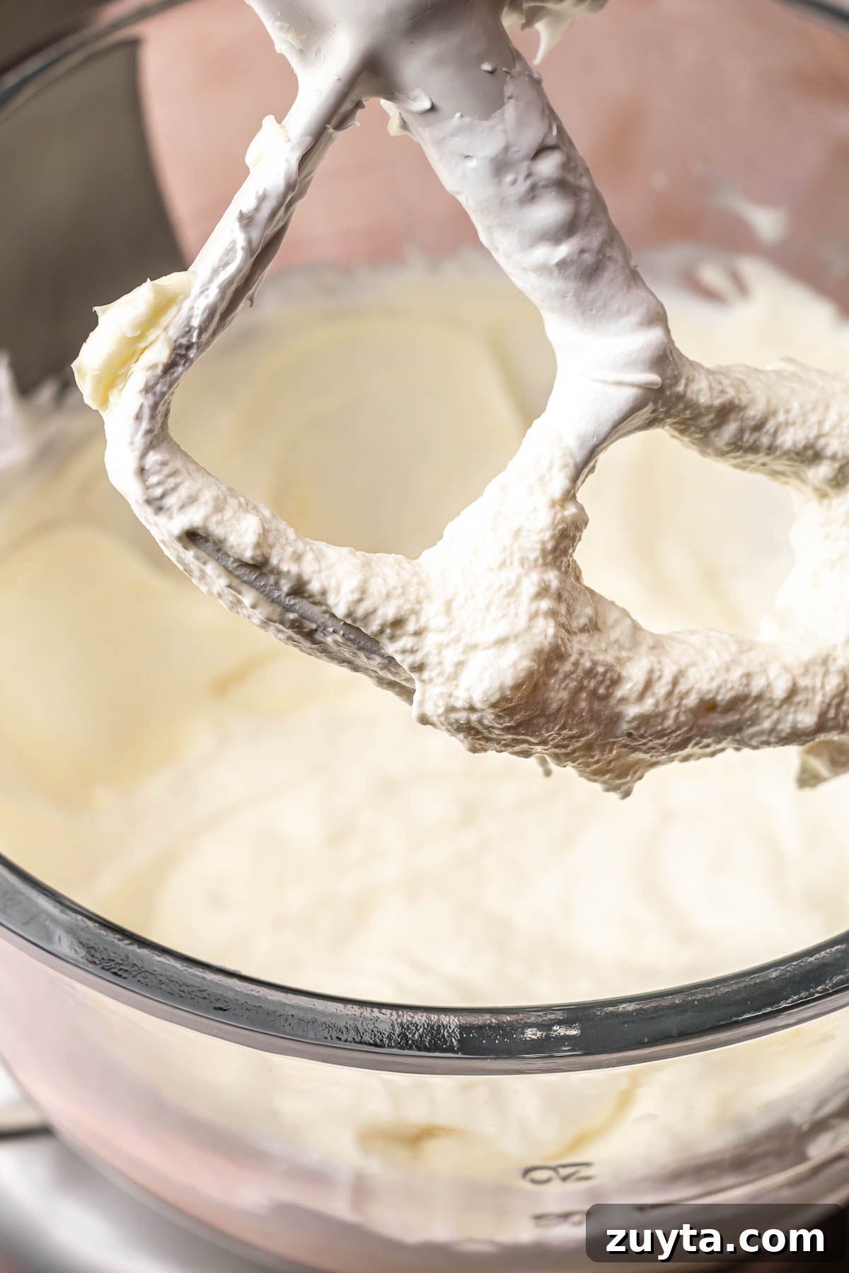 Silky Chocolate Swiss Meringue Buttercream Recipe 7 Soupy, curled looking swiss meringue buttercream in a bowl.