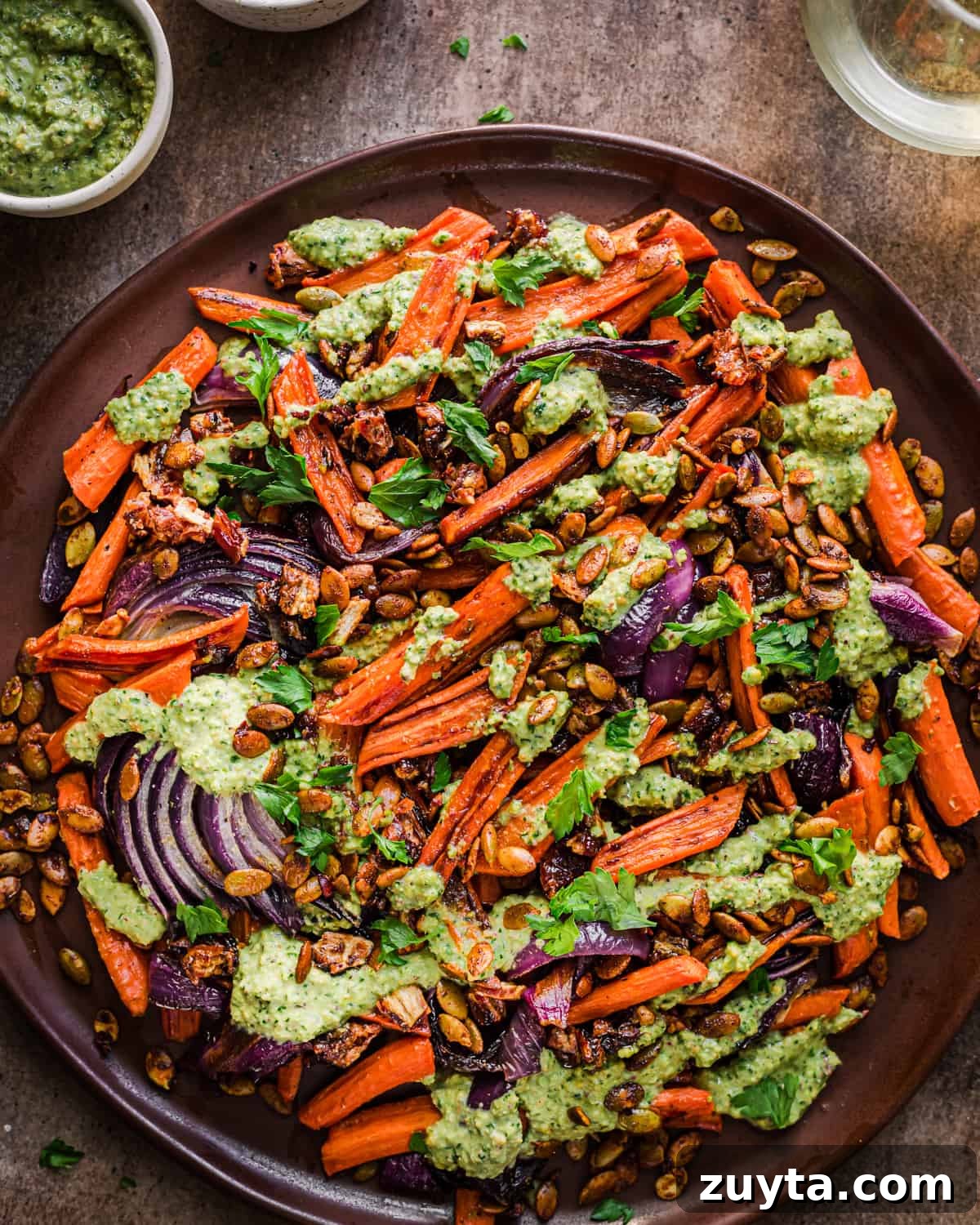 Maple-Roasted Carrots and Dates with Pistachio Pesto 14 Finished carrot and date dish on a brown plate.